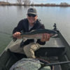 Angler in boat with large rainbow trout